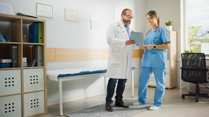Doctor's Office: Physician Stands, Talks With Professional Head Nurse, Using Digital Tablet...