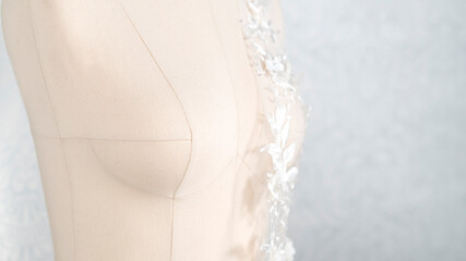 Obraz premium Woman sewing mannequin with white delicate lace fabric on it.