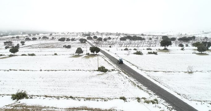 Carretera comarcal nevada con tractor