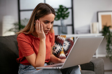 Fototapeta premium Young woman having video call. Beautiful woman enjoying at home.