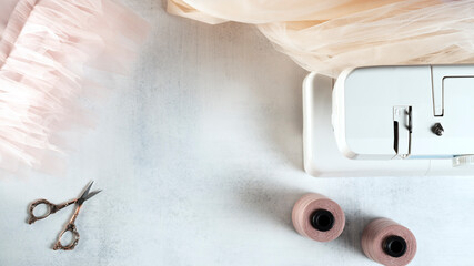 Seamstress workplace with tulle fabric and sewing machine. Selective focus.