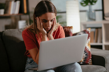 Naklejka premium Young woman having video call. Beautiful woman enjoying at home.