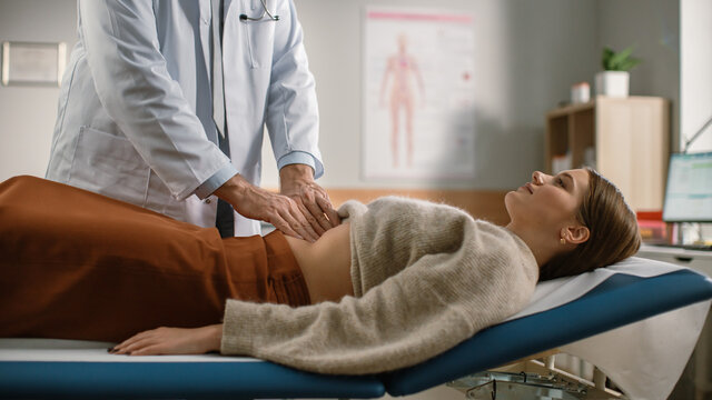 Doctor Consultation Office: Female Patient Lying on a Bed while Family Physician Checks Her Abdomen. Medical Health Care Specialist Localizes Stomach Pain, Identifying Disease, Prescribing Treatment 