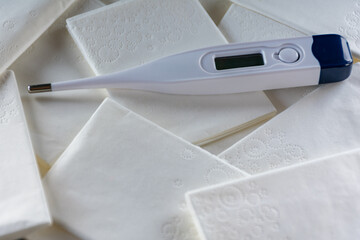 White thermometer on a pile of tissue.