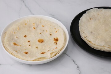 Rice bhakri, Chawal ki roti. It is a round soft flatbread. Usually eaten with fish, chicken or mutton thali. Served with garlic & green chutney. Copy space.