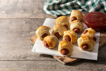 Pigs in blankets. Mini sausages wrapped in puff pastry with ketchup sauce. Copy space