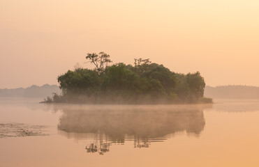Sunrise view of the isle amid fog on Jinshan Lake  with beautiful reflection in Zhenjiang, Jiangsu, China.