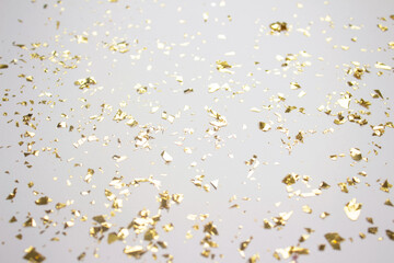 Festive background in light grey color with holographic flying golden sparkles for your project. Holiday backdrop with copyspace. Birthday party, Christmas or New Year celebration concept