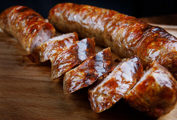 Homemade fried sausages on a wooden cutting board.