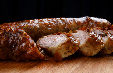 Homemade fried sausages on a wooden cutting board.