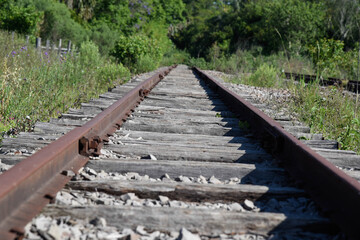 Old and abandoned railway and rails with rusty wooden sleepers in Brazil