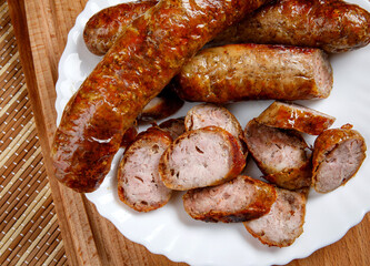 Homemade fried sausages in a white plate. Top view.