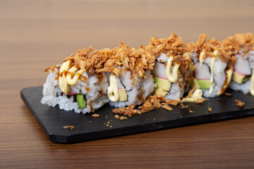 Crispy Sushi Roll with fried onion, avocado and crab. Sushi menu. Japanese food.
