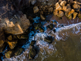 Fototapeta na wymiar Aerial view of sea waves crashing on the rocks