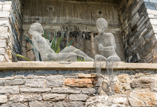 Orselina, Ticino, Switzerland - June 15, 2017: Insight - outlook, The sculpture depicts two seated people by Christa Lienhardin author, in the Orselina park, above Locarno in Ticino.