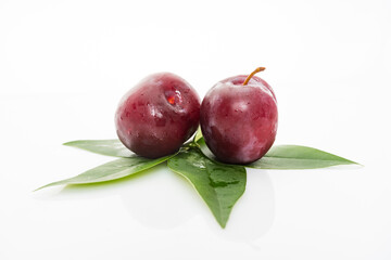 plums with plum leaves on a white background