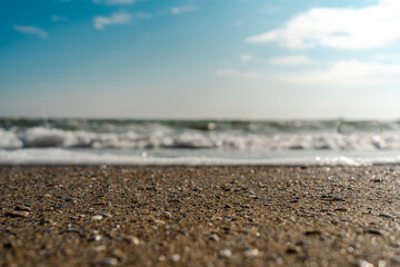 Closeup of wet stones in beach sand and wave