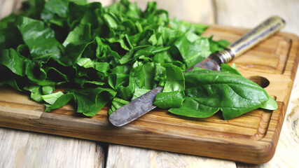 Sliced spinach on a wooden cutting board. Fresh juicy spinach for cooking.