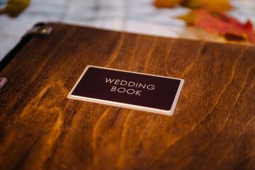Leather-bound wedding book with designer wood cover with chocolate-colored tag