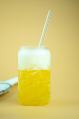 Glass of light beer with ice and straw