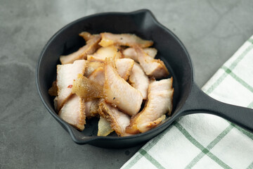 Charcoal-boiled pork neck served on black pan.