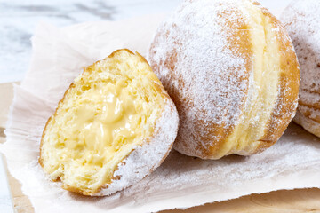 Close-up of donuts , Berlin pancakes, dusted with powdered sugar served on a rustic wooden table