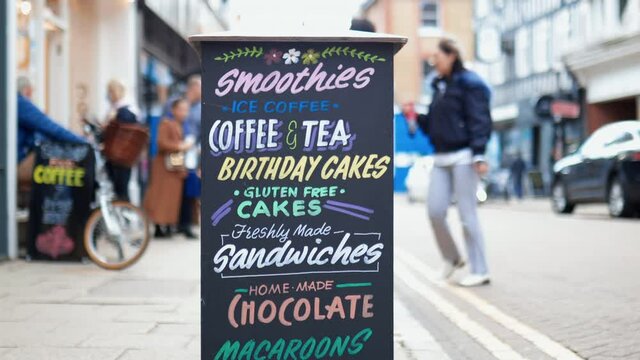 Sign with restaurant menu on the crowded tiled sidewalk