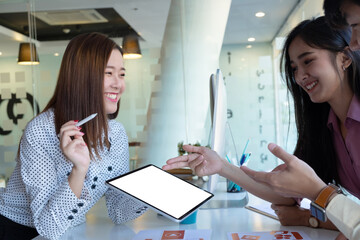 Cropped shot of two UI developers meeting on their project with paperwork and tablet on meeting...