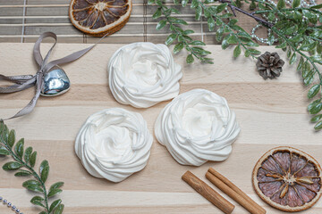 mug of coffee on a wooden table, air meringue, dried orange, cinnamon and accessories for winter holidays. New Year