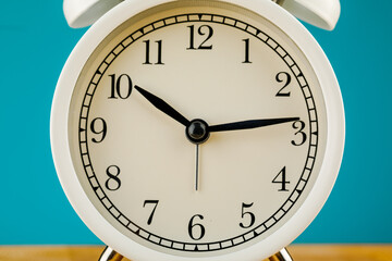 beige vintage alarm clock on a blue background