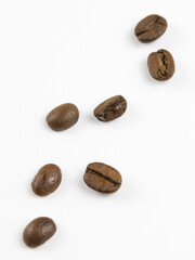 Naklejka premium a few isolated coffee beans on a white background, a close-up
