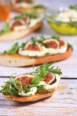 Bruschetta with mozzarella, arugula and figs, seasoned with honey and spices