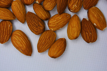 Delicious and healthy brown nuts, almonds, almonds set on a white matte background.