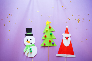 paper craft for kids. snowman, Santa Claus and christmas tree on purple background. create art for children. new year concept