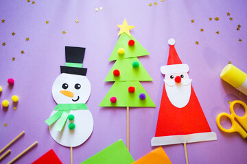 paper craft for kids. snowman, Santa Claus and christmas tree on purple background. create art for children. new year concept