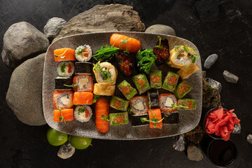 Big sushi set. A dish of Japanese cuisine. Sushi rolls with chuka salad, salmon, philadelphia maki with cream cheese, sashimi, gunkans with red caviar, avocado and Japanese tamago omelet.