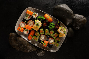 Big sushi set. A dish of Japanese cuisine. Sushi rolls with chuka salad, salmon, philadelphia maki with cream cheese, sashimi, gunkans with red caviar, avocado and Japanese tamago omelet.