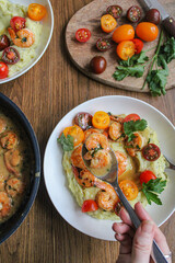 Pouring shrimps with garlic sauce over mashed potatoes plate. Plating spring dish. Beautiful food. Slow life. Slow cooking, 