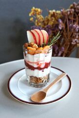 Strawberry smoothies, yogurt and fresh fruit in a glass on a white table.