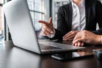 Office female manager finger pointing on the laptop screen. Office business collegues working with laptop, no face, Man and female managers in office with laptop, concept of work