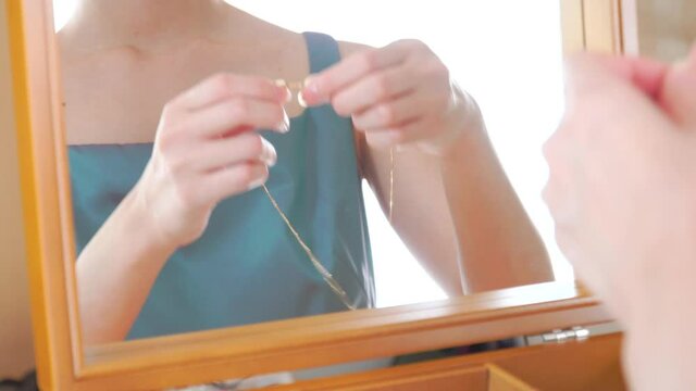 トパーズのネックレスをつけるドレスの女性