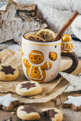 Cup with mulled wine or punch or spiced tea with christmas cookies, harmonious light colors, vertical stock photo
