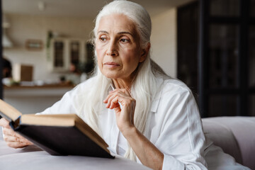 Calm senior woman reading a book