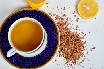 Cup of tea, Catuaba bark and lemon on white background. Natural herbal tea from Catuaba tree bark,...