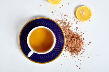 Obraz na płótnie Canvas Cup of tea, Catuaba bark and lemon on white background. Natural herbal tea from Catuaba tree bark, natural aphrodisiac from Brasilia