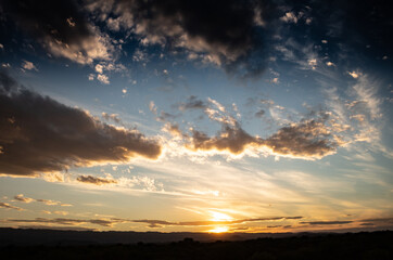 Shocking sunset between the field. Landscape with distant mountains during sunset.
