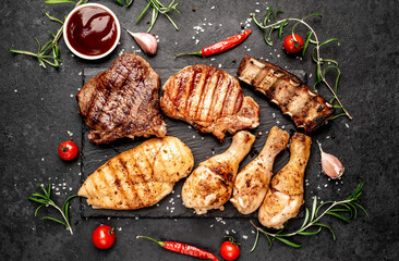 Various types of grilled meat, beef, pork, chicken on stone background