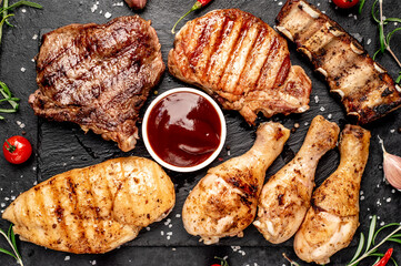 Various types of grilled meat, beef, pork, chicken on stone background