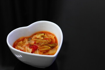 白いハートの器に入った健康的な野菜スープ	