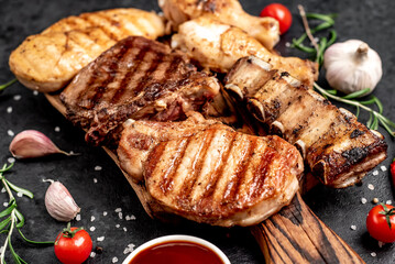 Various types of grilled meat, beef, pork, chicken on stone background